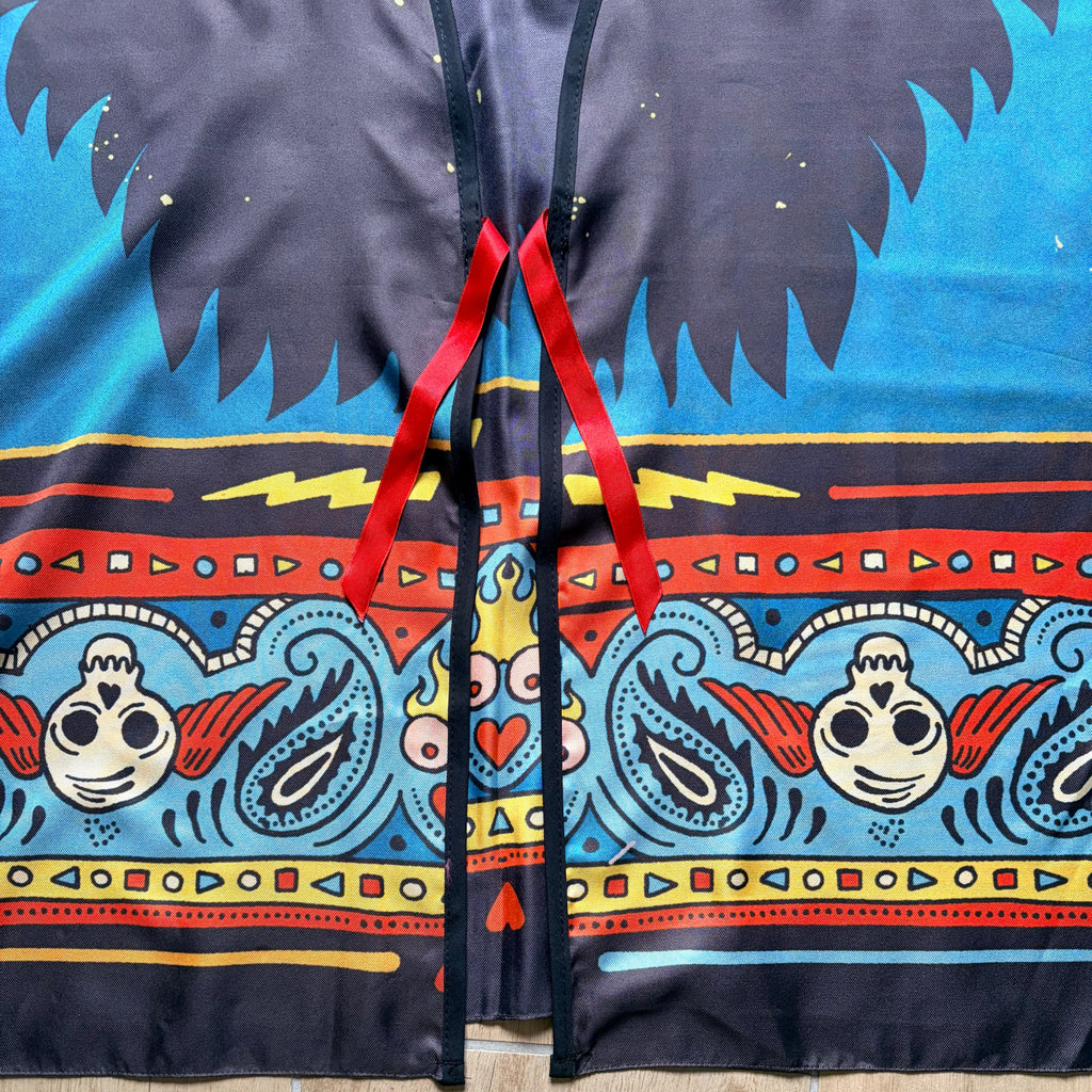 Dettaglio chiusura kimono "Bandana" ARYK OLD PAINT – laccio rosso su illustrazione con teschi alati, motivi paisley e fulmine, stile old school